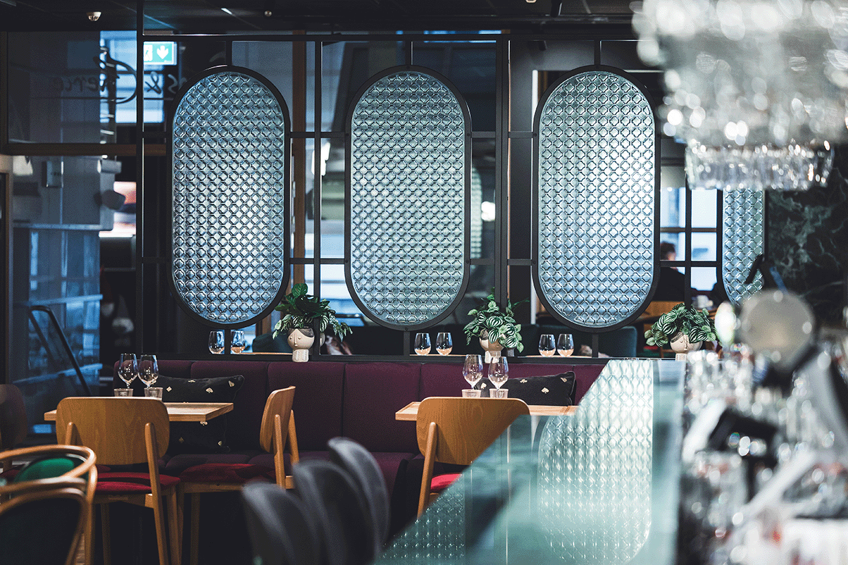 Bronze-toned Retro artisan glass used as a room divider in a restaurant interior.