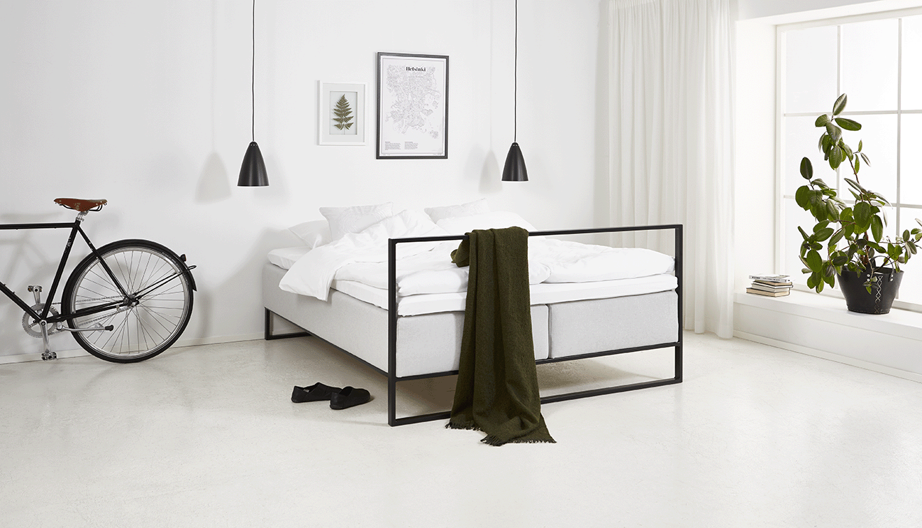 Low PETI bed frame integrating a tidy storage slot at the foot for a daytime cover.