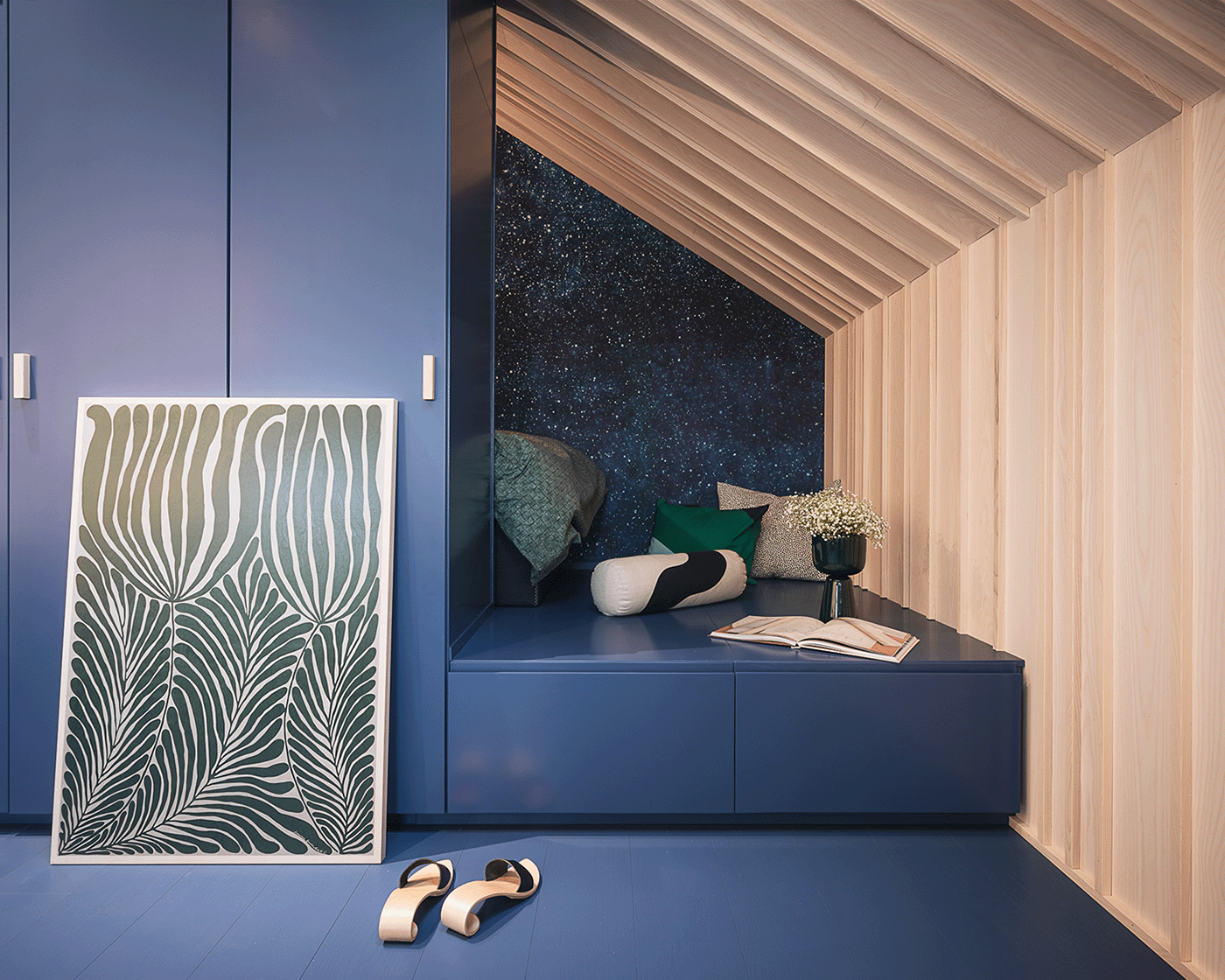 Blue-stained parquet floor and built-in blue cabinetry creating a calm atelier and reading nook.