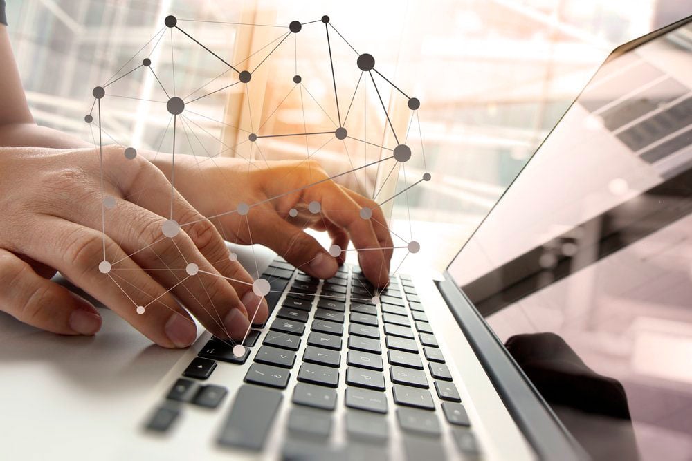 Double-exposure-of-business-man-hand-working-on-blank-screen-laptop-computer-on-wooden-desk-as-concept-with-social-media-diagram-1